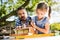 Father with a small daughter outside, making wooden birdhouse.