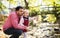 Father with small daughter on a walk in autumn forest, resting and talking.