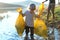 Father with small son collecting rubbish outdoors in nature, plogging concept.