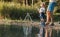 A father with a small toddler son outdoors fishing by a lake.