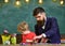 Father and son at the art class. Daddy holding brushes for his boy. Developing creativity