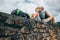 Father and son backpacker traveler rest together on old stone wa