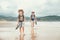 Father and son backpacker traveler walk on sand ocean beach