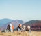 Father and son backpackers hikers rest on mountain hill with their beagle dog