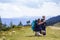 Father and son with backpacks hiking together in scenic summer green mountains. Dad and child standing enjoying landscape mountain