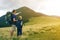 Father and son with backpacks hiking together in summer mountains. Back view of dad and child holding hands on landscape mountain