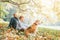 Father, son and beagle dog sitting in autumn park, warm indian s