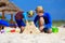 Father and son building sand castle on tropical