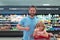 Father and son buy fresh vegetable in grocery store with thumbs up. Family in shop.