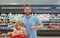 Father and son buy fresh vegetable in grocery store with thumbs up. Family in shop.