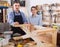 Father and son chiselling a wooden bench in workshop