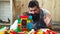 Father and son create colorful constructions with toy bricks. Kids early education. Happy child playing with dad baby