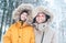 Father and son dressed in Warm Hooded Casual Parka Jacket Outerwear walking in snowy forest cheerful smiling faces portrait.