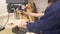 Father and son drills the wooden plank using joinery machine in carpentry workshop