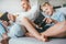 Father and son emotionally playing with electronic devices: tablet and gamepad sitting in living room