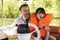 Father And Son Enjoying Day Out In Boat On River Together