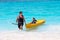 Father and son enjoying kayak ride on troical beach