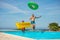 Father and son excited jumping into pool with colorful floats