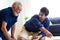 Father and son family time together at home concept. Bearded olf Father and Bearded middle age Son Playing Toy train on floor at