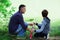 Father with son fishing at river bank, summer outdoor. Man and young boy standing at river bank with rod and fishing. Family