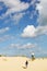 Father and Son Flying Kite on sand dune on beach