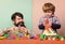 Father son game. Father and son create colorful constructions with bricks. Bearded father and boy play together. Dad and