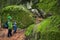 Father and son on haking trail near huge stones covered by green moss. Active family outdoor. Travel adventure with child