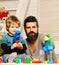 Father and son with happy faces create colorful constructions