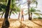 Father and son happy jump and run under palm trees on the tropic