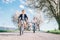 Father and son having fun when riding bicycles on country road under blossom trees. Healthy sporty lifestyle concept image