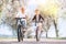 Father and son having fun when riding bicycles on country road under blossom trees. Healthy sporty lifestyle concept image