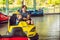 Father and son having a ride in the bumper car at the amusement park