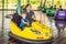 Father and son having a ride in the bumper car at the amusement park