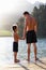 Father and son holding hands standing on jetty