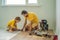 Father and son installing new wooden laminate flooring on a warm film floor. Infrared floor heating system under
