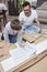Father and son kneel on the carpet in front of the box with elements for self-assembly and read the assembly instructions
