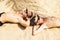 Father and son lie on the sand in palm tree shadow. Tropical isl