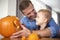 Father and son making carved pumpkin