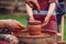 Father and son making ceramic pot. Family working on pottery wheel. Potters and child hands