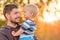 Father and son outdoor portrait in sunset sunlight