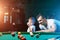 Father and son play billiards. The father teaches his son to play billiards. The concept of parents and children, upbringing,