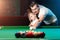 Father and son play billiards. The father teaches his son to play billiards. The concept of parents and children, upbringing,