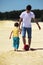 Father with son play football on sand