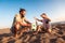 Father and son play soccer or football on the beach having great family time on summer holidays