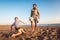 Father and son play soccer or football on the beach having great family time on summer holidays