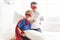 Father and son play superheroes on bed at home