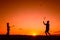 Father and son playing badminton in the evening, silhouettes of people exercising in nature