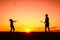 Father and son playing badminton in the evening, silhouettes of people exercising in nature