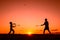 Father and son playing badminton in the evening, silhouettes of people exercising in nature