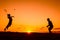 Father and son playing badminton in the evening, silhouettes of people exercising in nature